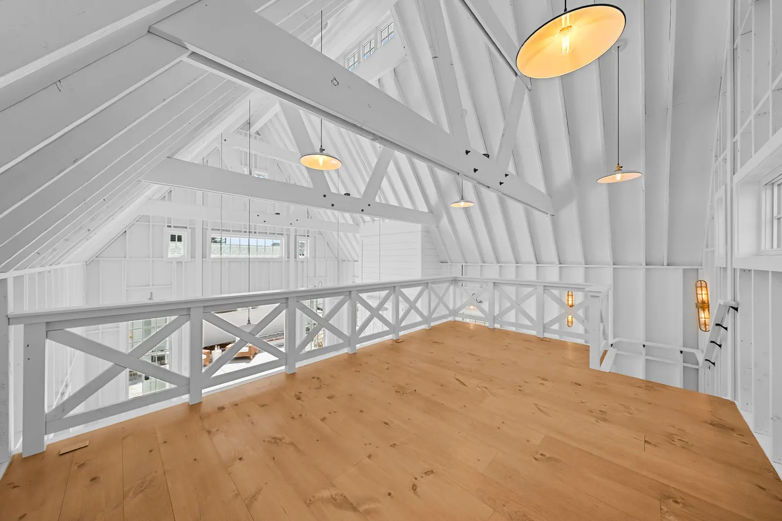 Vaulted white loft with exposed trusses and a cross-rail balustrade