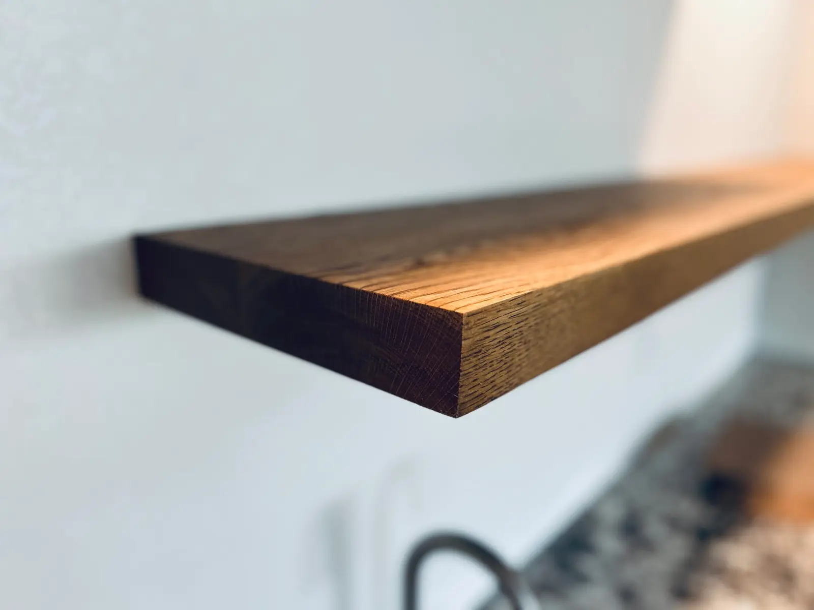 Close-up of a dark wood floating shelf edge