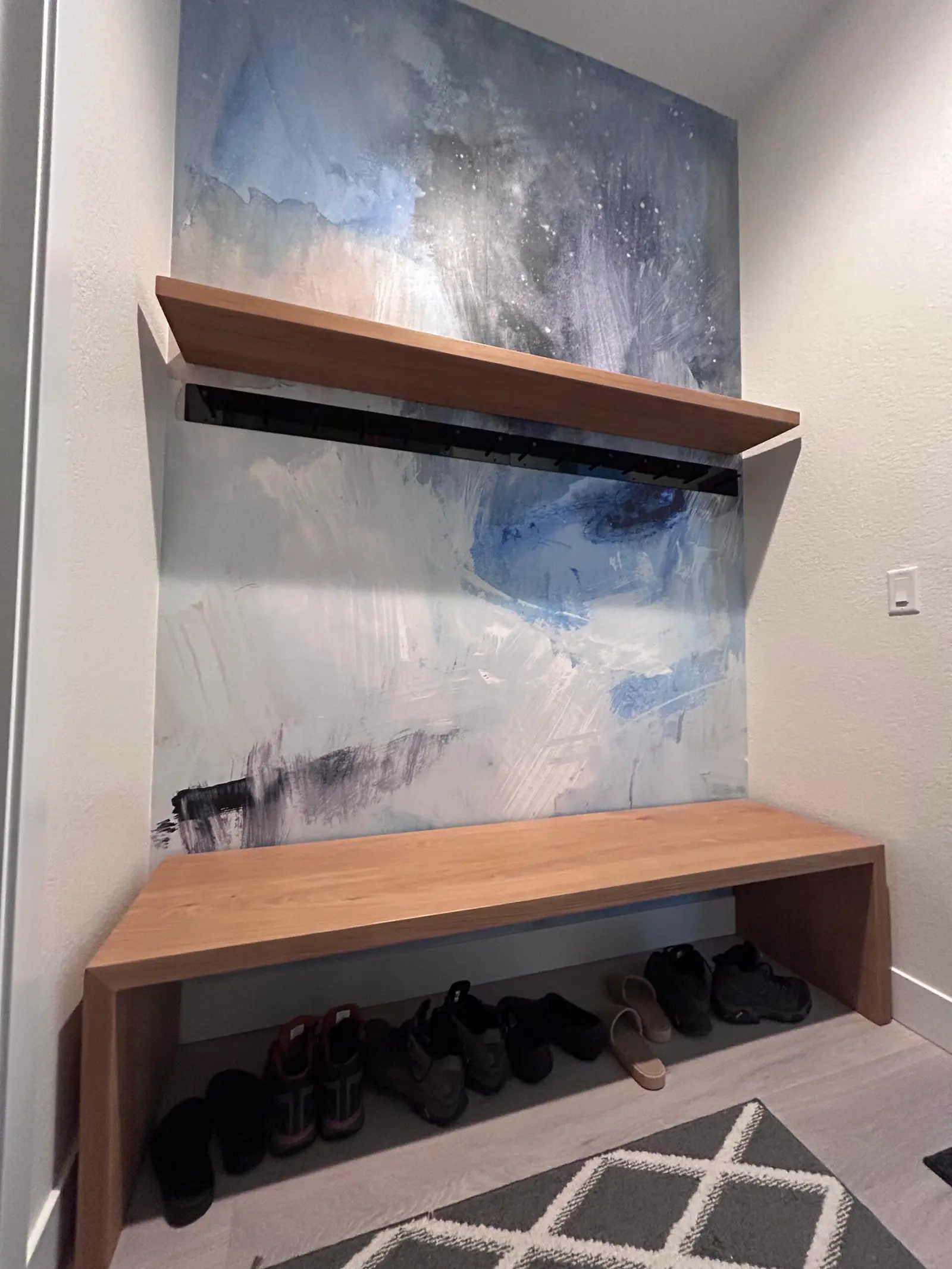 Entry bench with shoe storage below two floating shelves