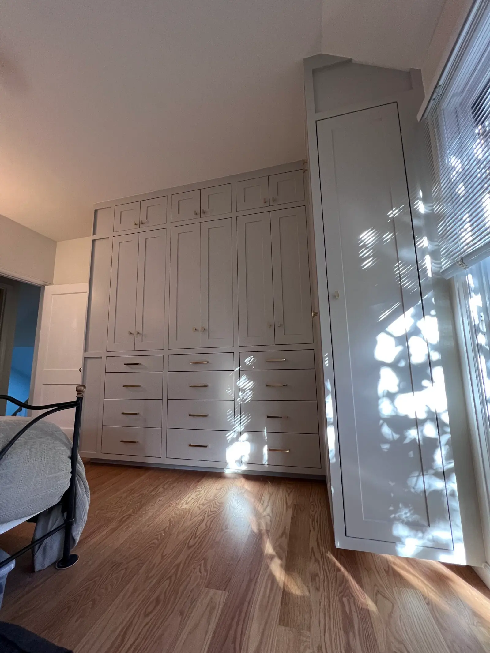 Bedroom wall of white built-in cabinets and drawers