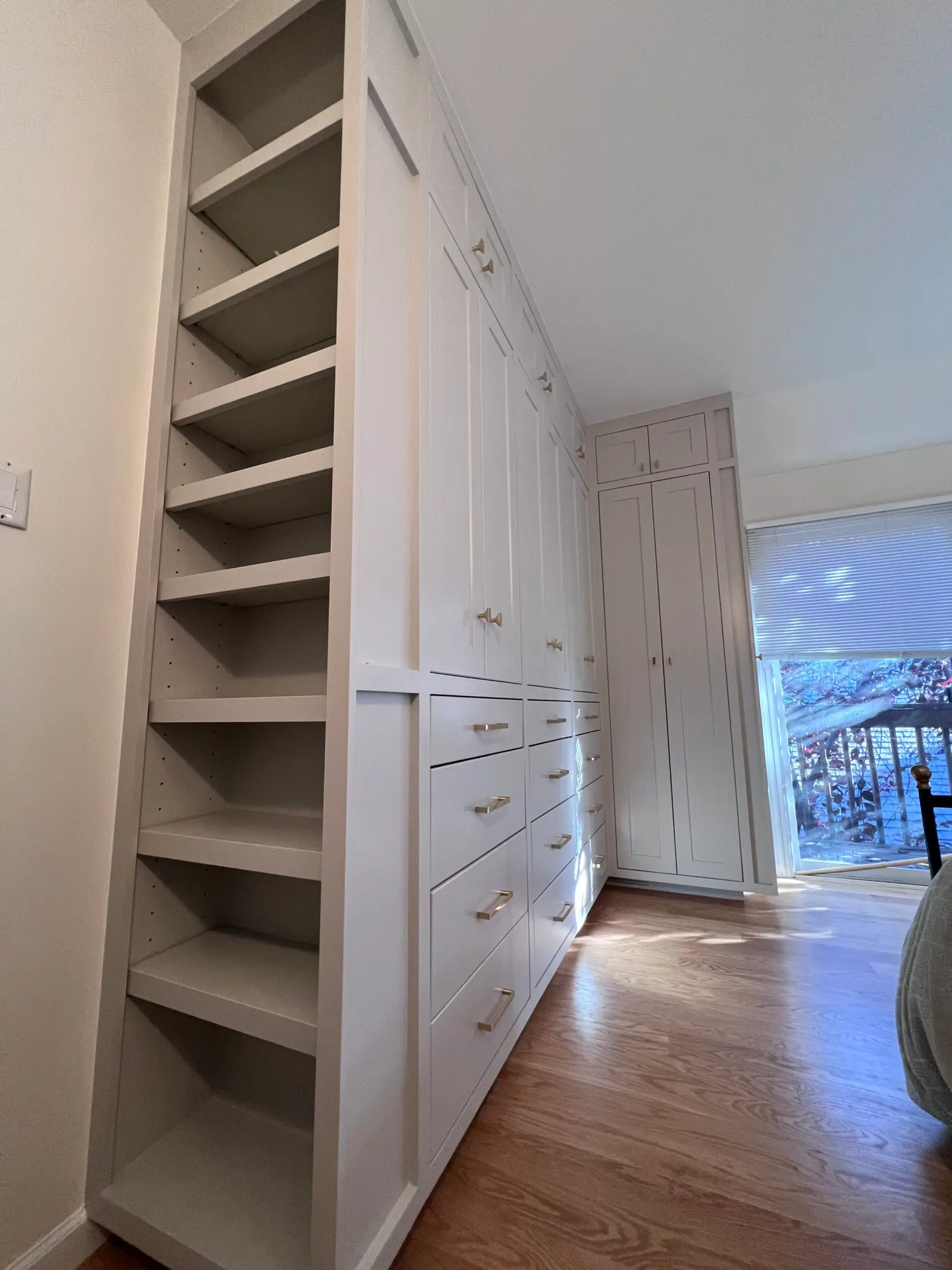 Built-in shelving and closet cabinetry along a bedroom wall