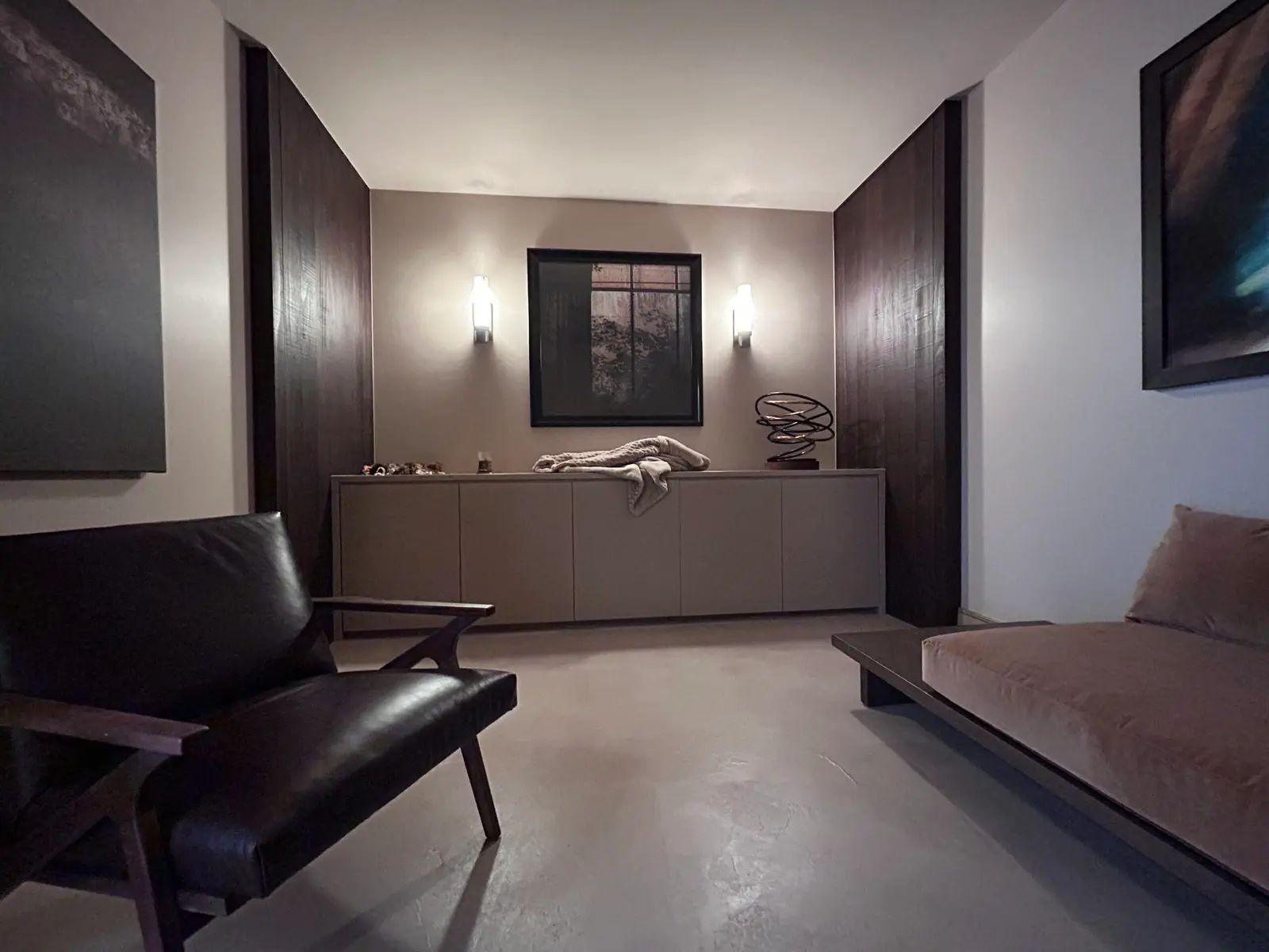Living room with dark paneled walls and a long low credenza