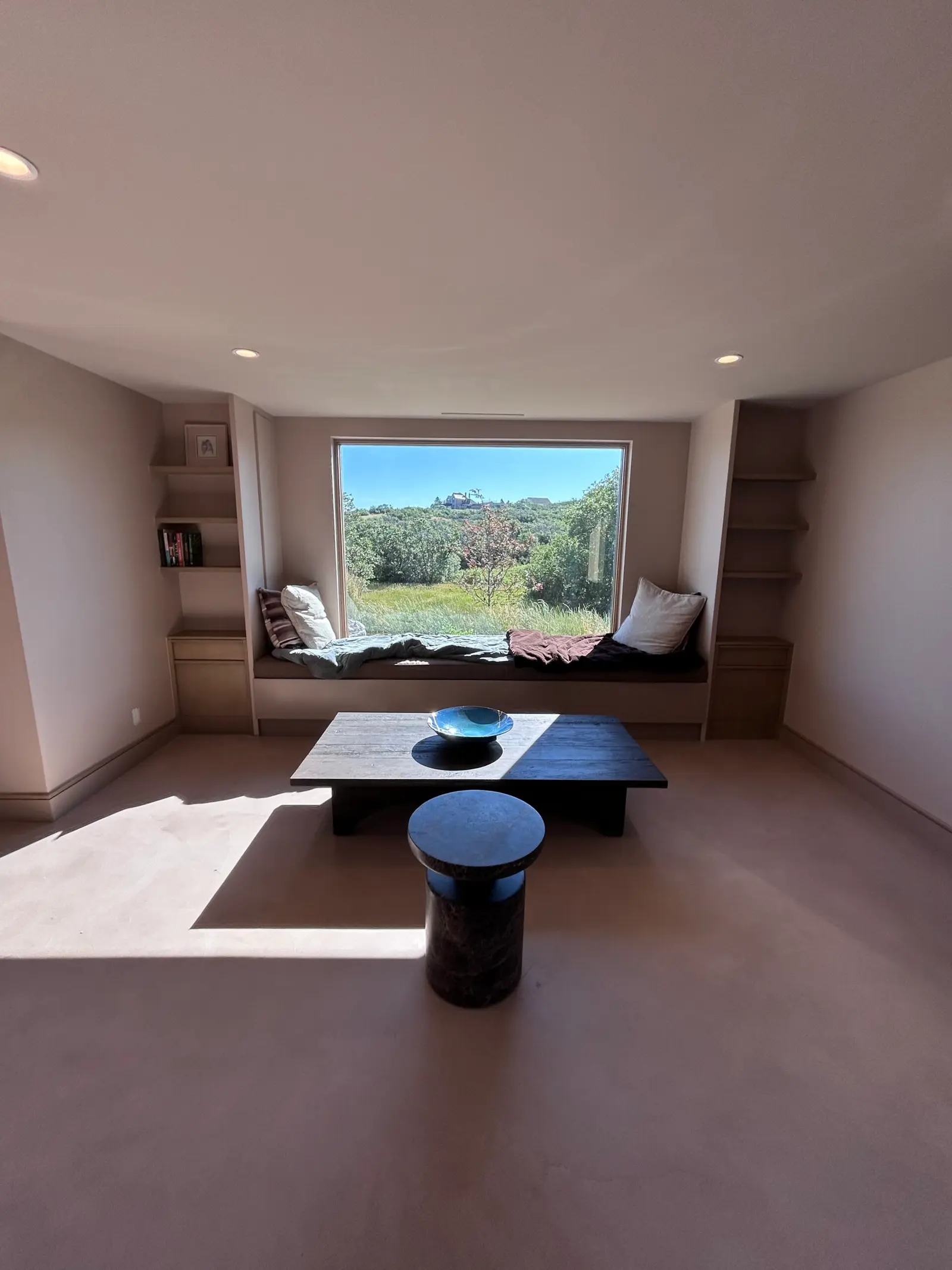 Window seat with built-in shelving framing a large picture window