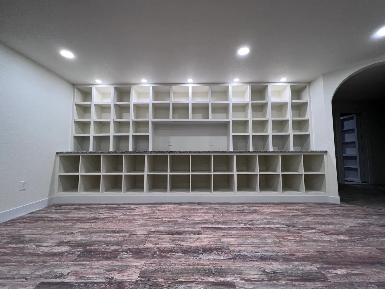 Wall of white built-in cubby shelving