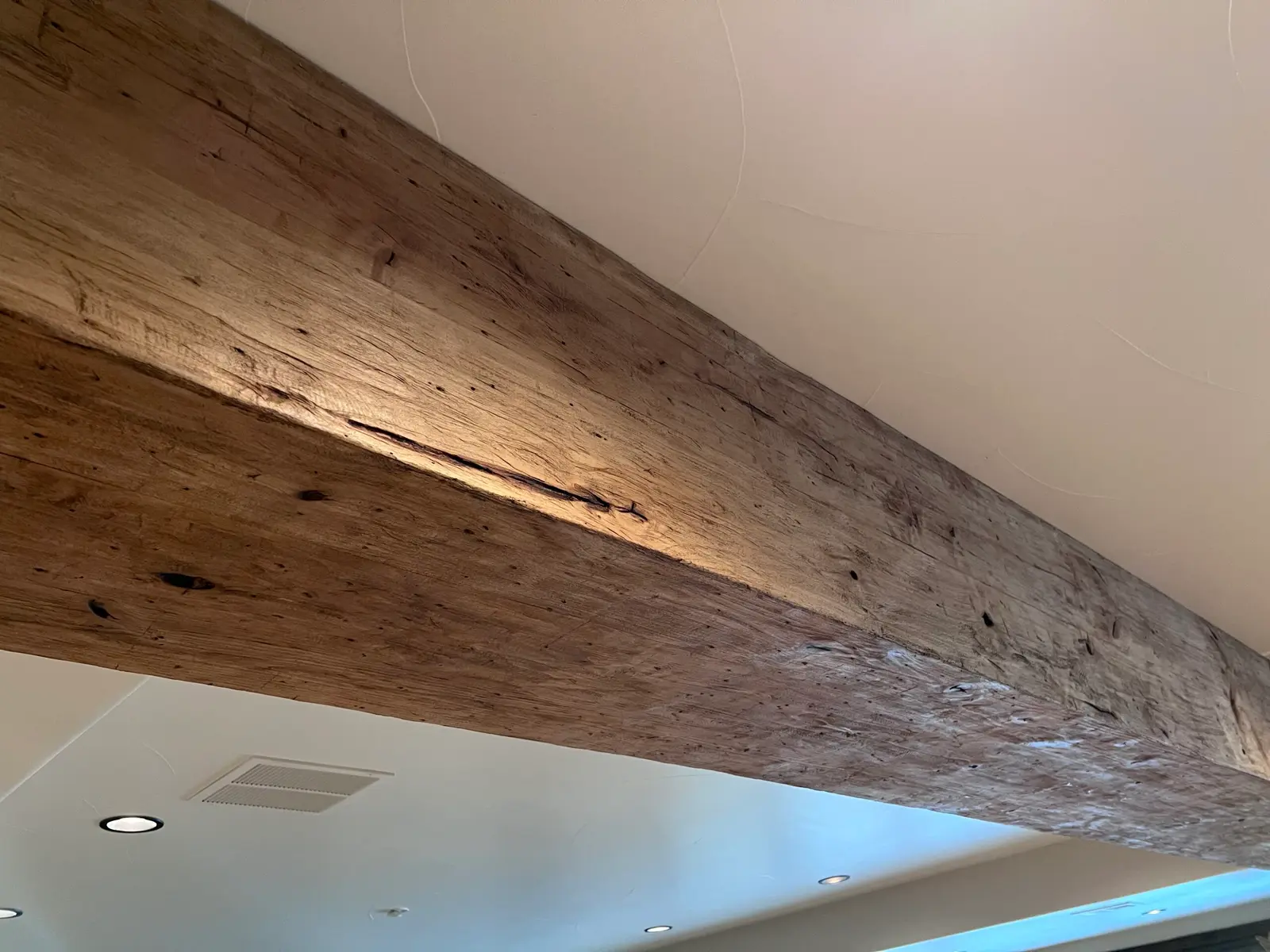 Close-up of a textured wood faux beam running along a ceiling