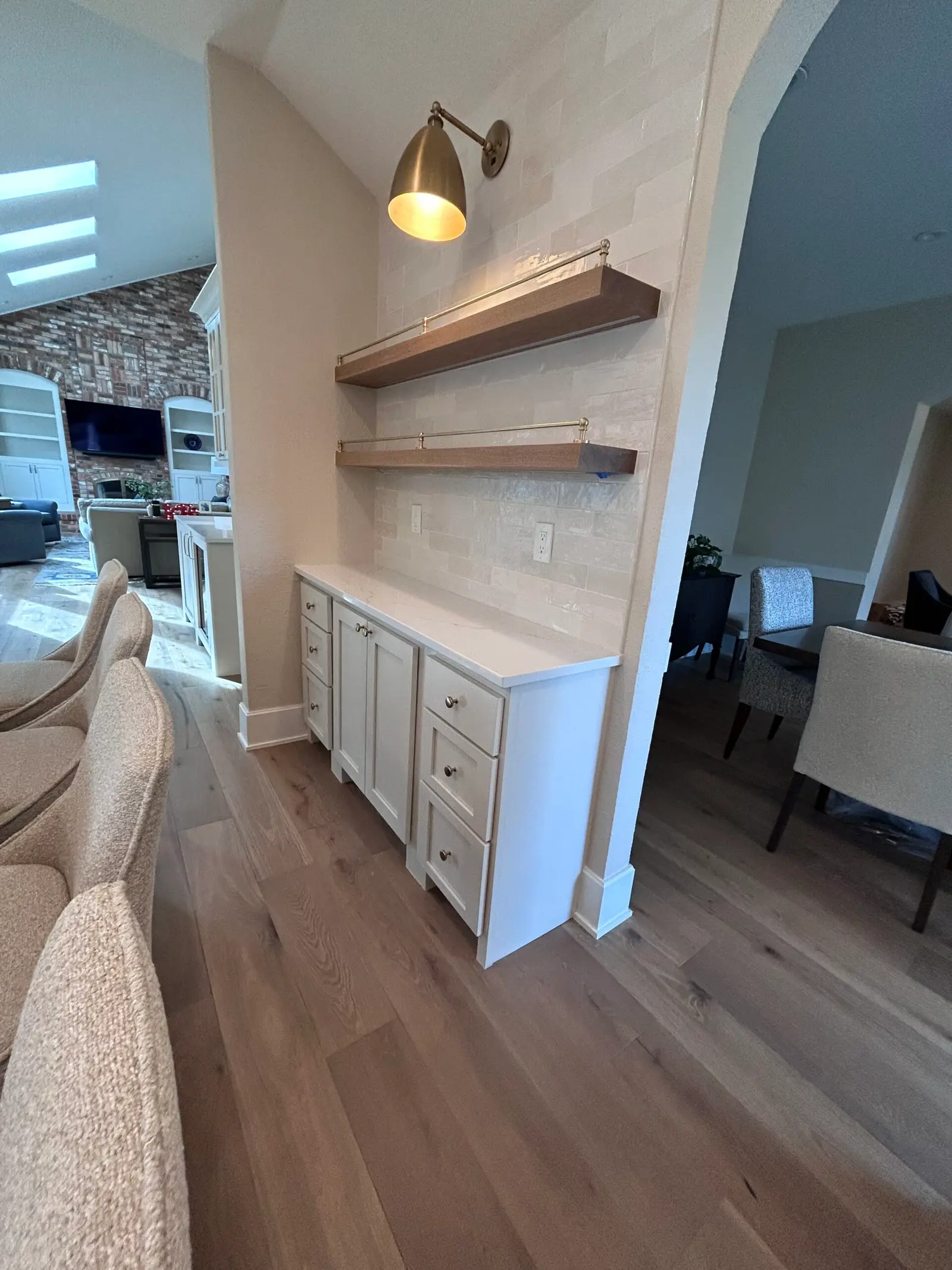 Floating wood shelves above white cabinetry in a kitchen