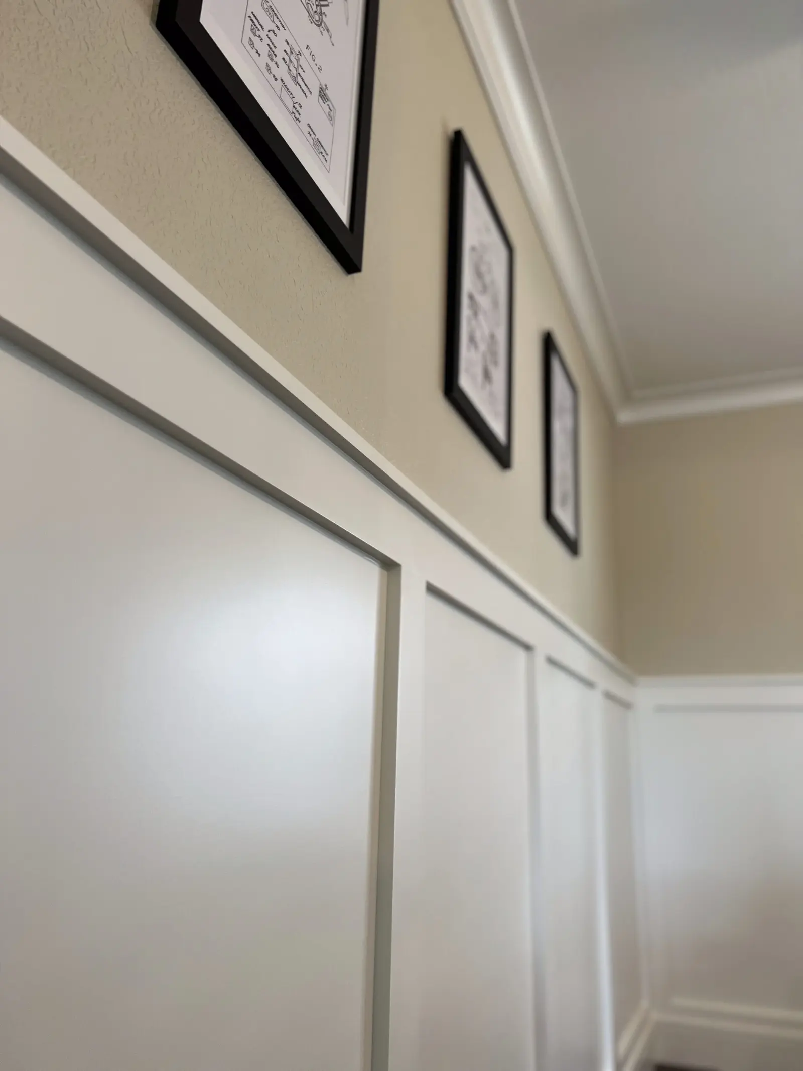 Hallway with white wainscoting panels and a cap rail