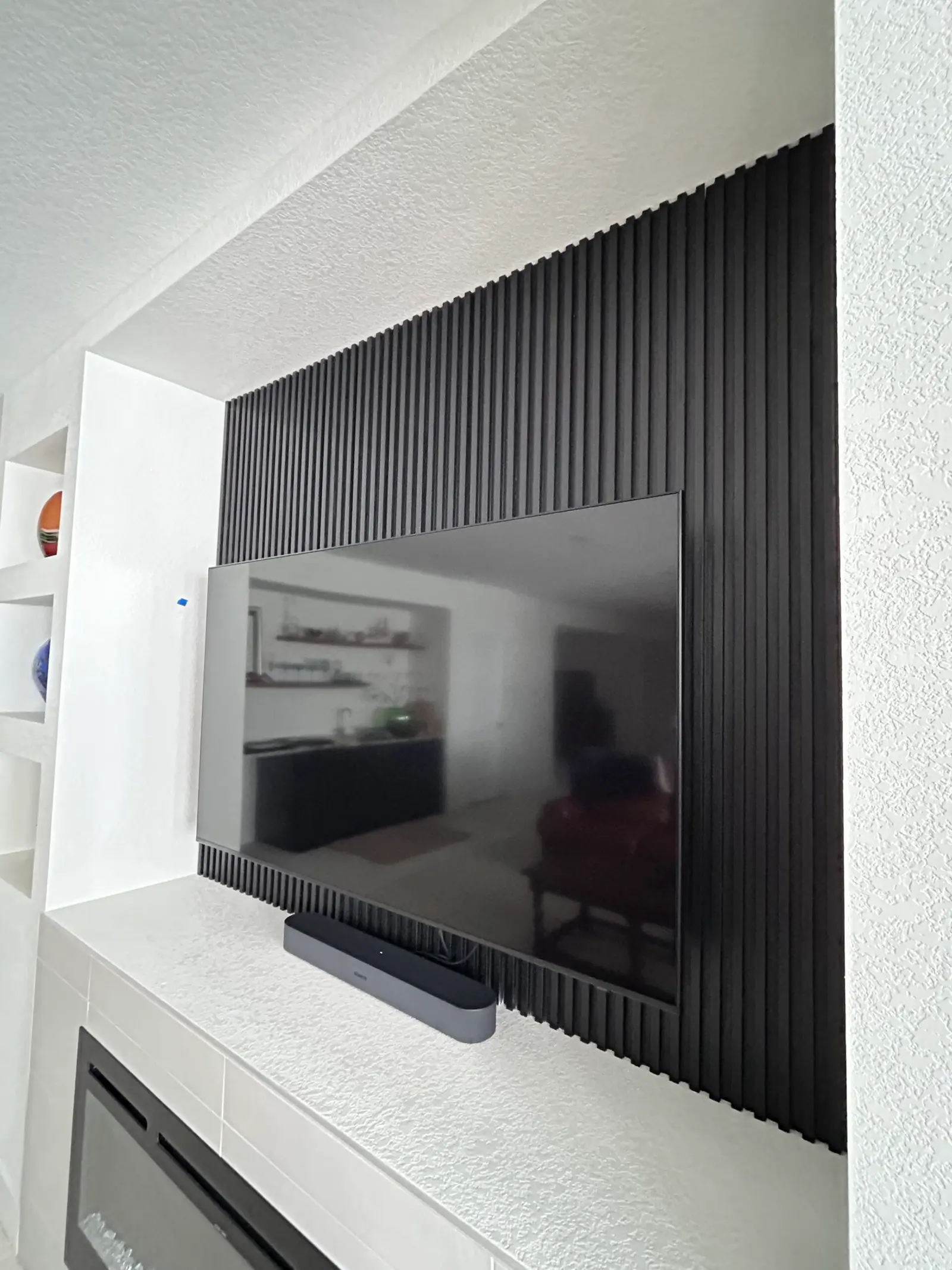 TV wall framed in black vertical slats