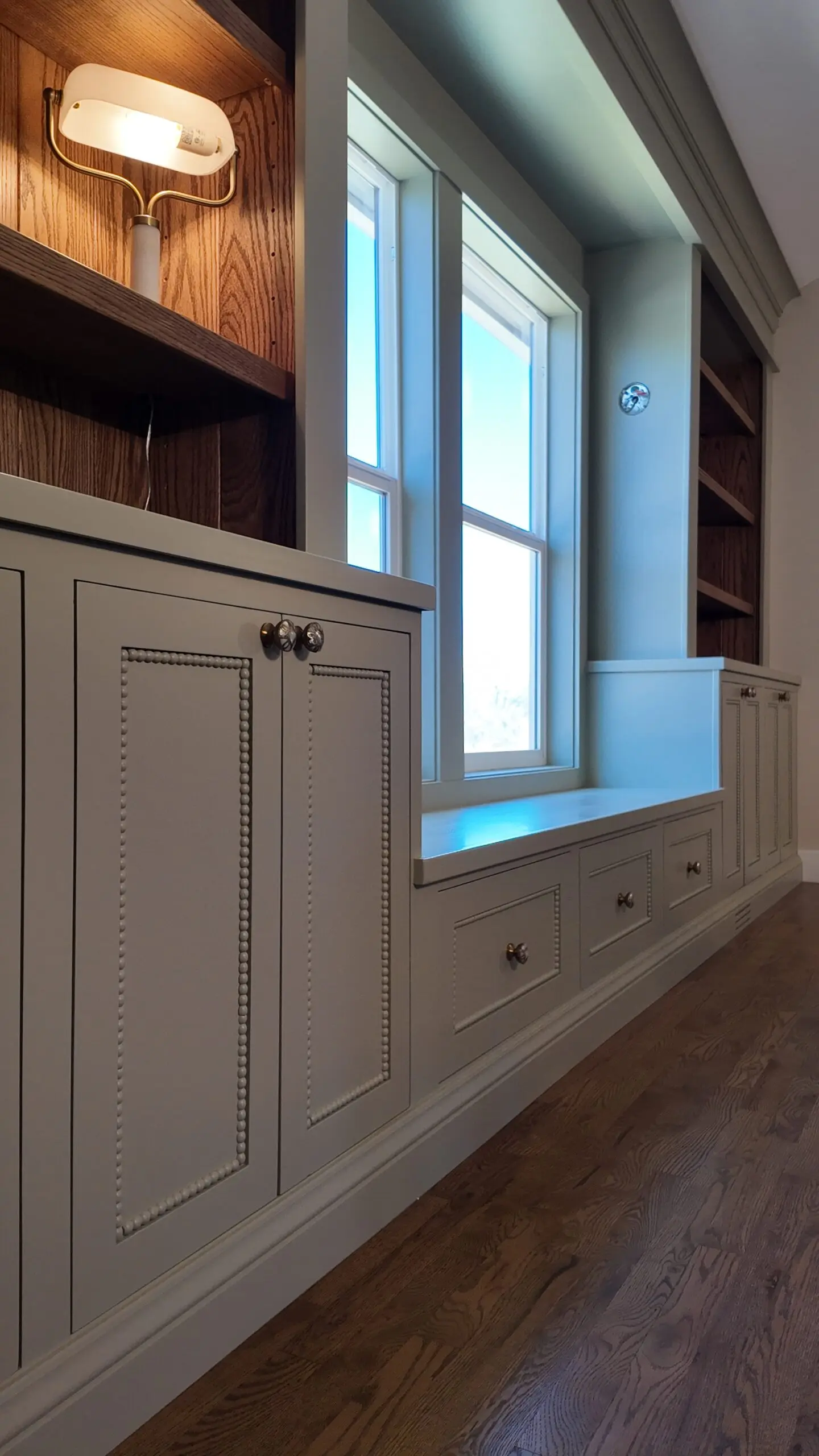 Painted built-in cabinetry and window seat with wood-lined shelving