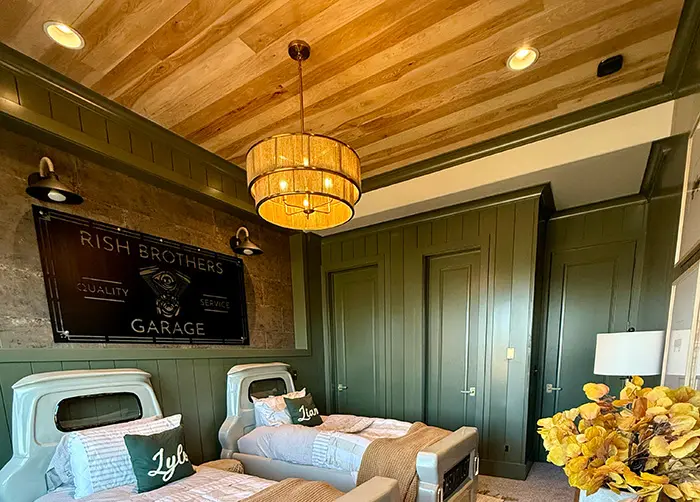 Bedroom with green paneled walls and a warm wood plank ceiling
